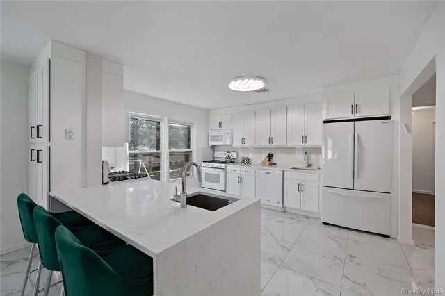 a kitchen with white cabinets and white appliances