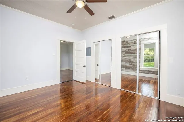 a view of empty room with wooden floor