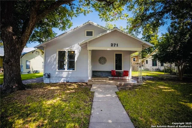 a view of a house with backyard and a tree