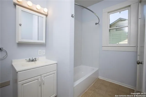 a bathroom with a sink a vanity and a bathtub