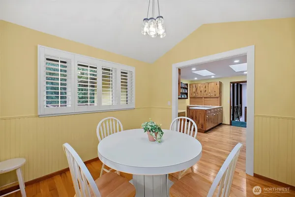 a view of a dining room with furniture a chandelier and wooden floor
