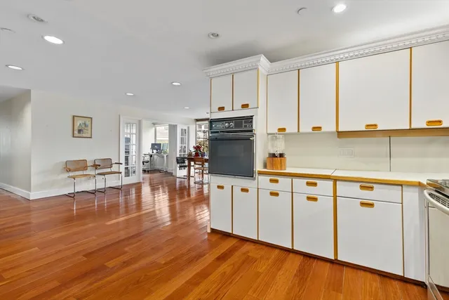 a kitchen with stainless steel appliances granite countertop a stove top oven a sink dishwasher and cabinets with wooden floor