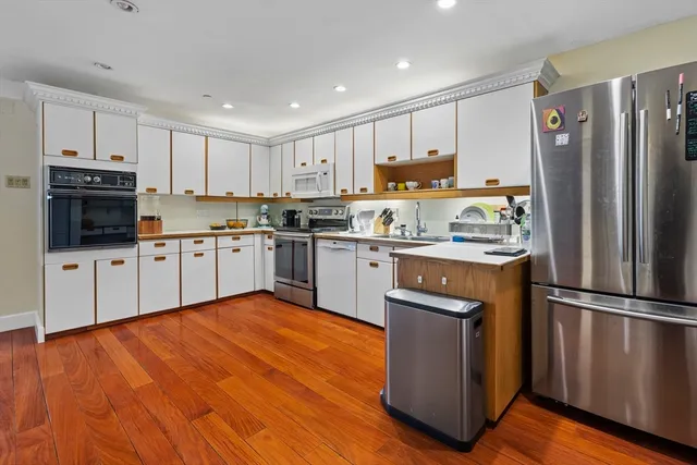 a kitchen with stainless steel appliances granite countertop a refrigerator a sink a stove a microwave and cabinets