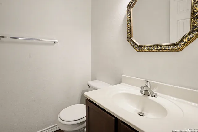 a bathroom with a sink mirror and toilet