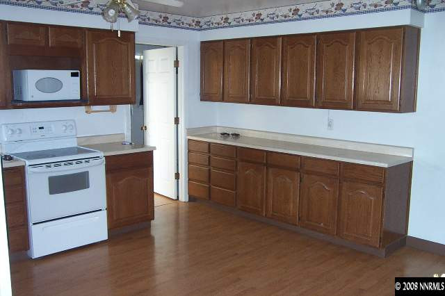 1952 South Allen Road Fallon, NV 89406 - Photo 3 of 8 a kitchen with wooden cabinets and white appliances