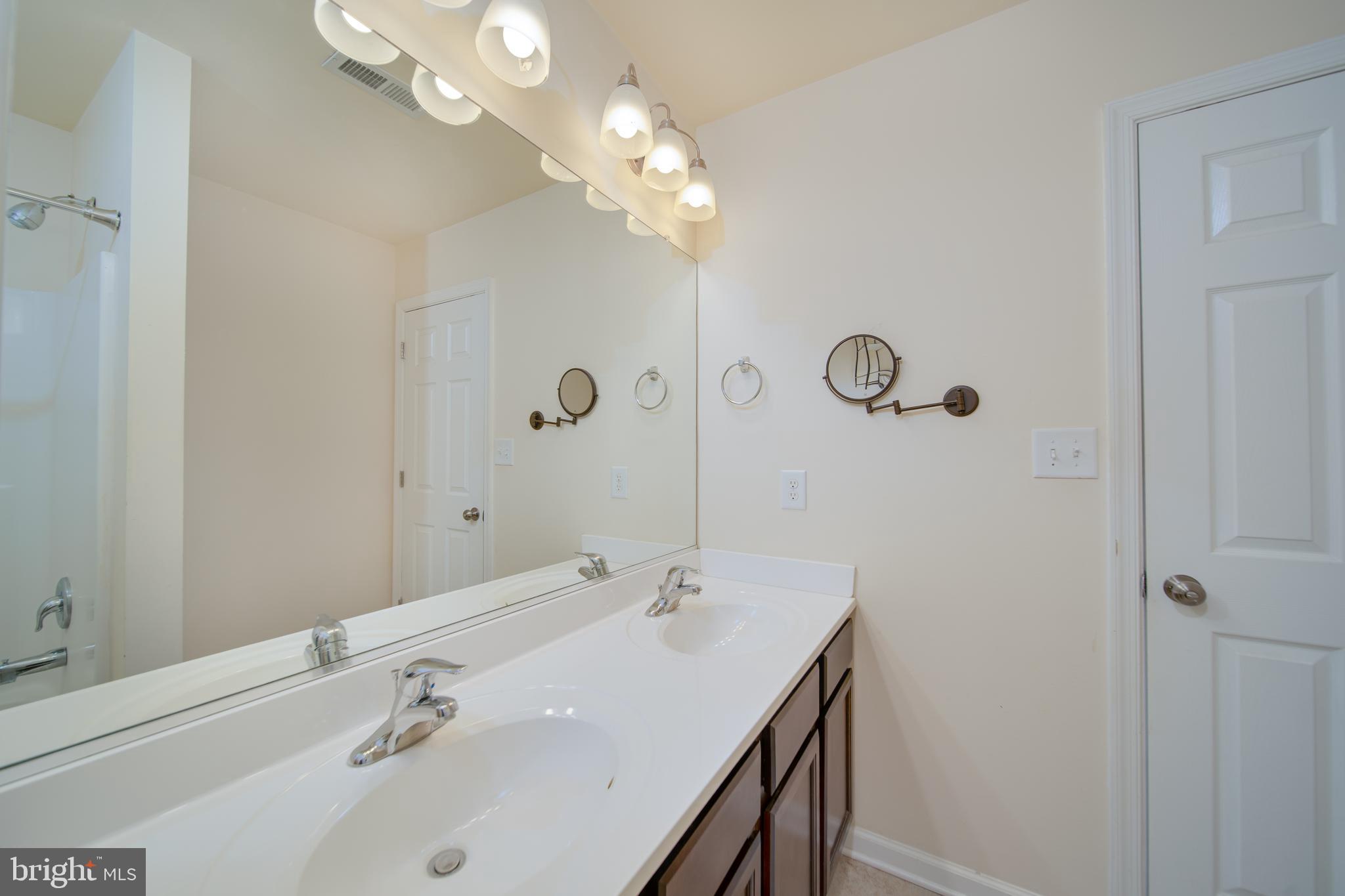 35 Montague Way Inwood, WV 25428 - Photo 14 of 38 a bathroom with a double vanity sink and a mirror