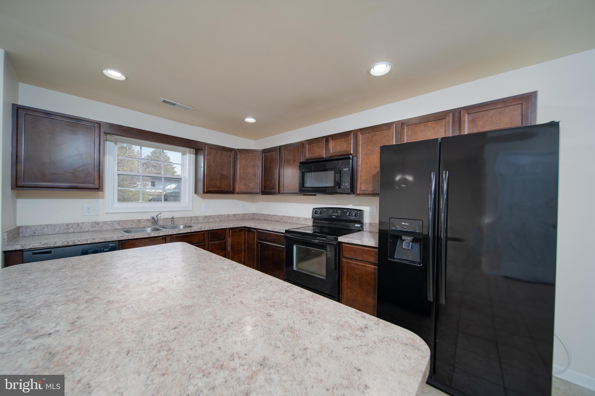 35 Montague Way Inwood, WV 25428 - Photo 4 of 38 a kitchen with granite countertop a refrigerator and a sink