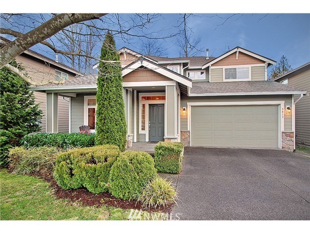 5813 Northeast 1st Place Renton, WA 98059 - Photo 1 of 1 a front view of a house with a garden and garage