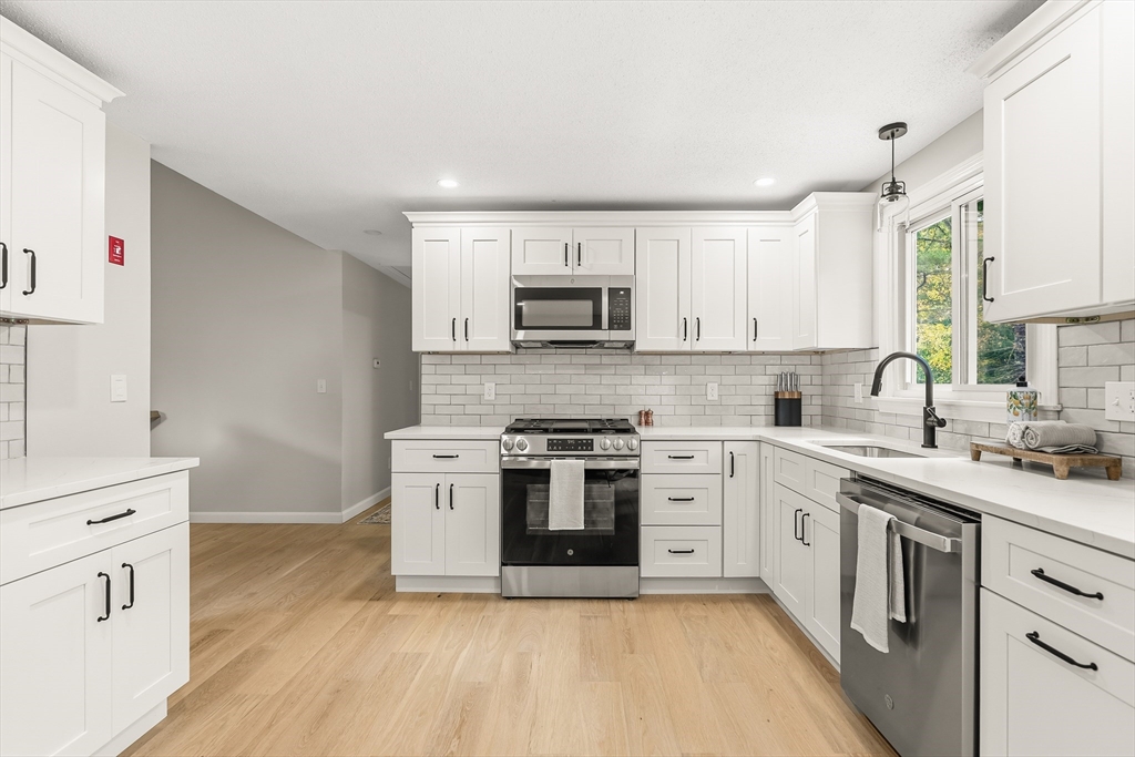 293 Mendall Road Acushnet, MA 02743 - Photo 15 of 41 a kitchen with stainless steel appliances granite countertop a stove top oven a sink dishwasher and a refrigerator with wooden floor