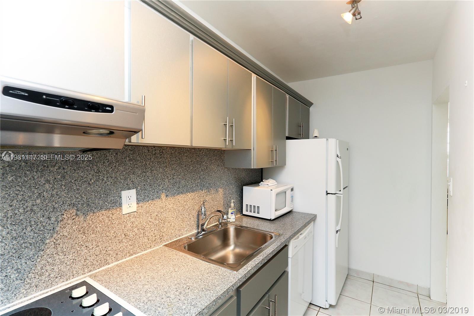 100 Lincoln Road, Unit 509 Miami Beach, FL 33139 - Photo 7 of 20 a kitchen with a sink a stove and refrigerator
