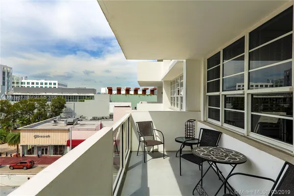 a balcony with table and chairs