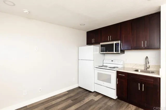 a kitchen with a sink a stove a microwave and cabinets