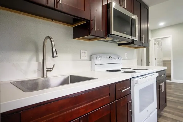 a kitchen with stainless steel appliances sink a stove and microwave