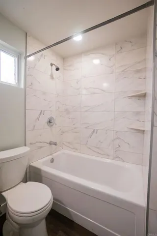 a bathroom with a toilet and a bathtub