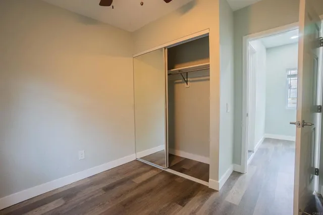 a view of an empty room with closet and a window