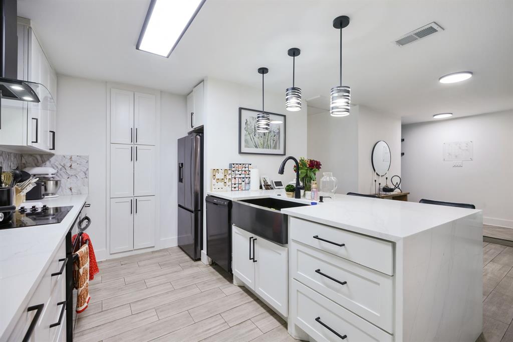 1831 Wintergreen Road Carrollton, TX 75006 - Photo 7 of 28 a kitchen with a sink dishwasher a stove and a refrigerator with wooden floor