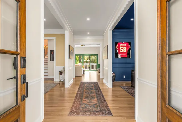 view of a hallway with wooden floor and a living room