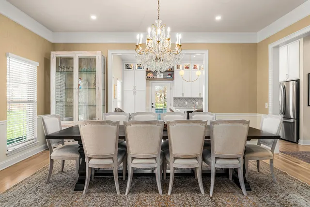 a dining room with furniture a chandelier and wooden floor