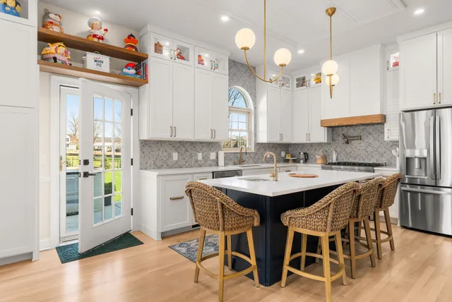 a kitchen with a sink and chairs