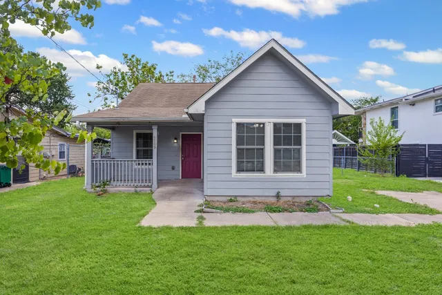 a view of a house with a yard and porch