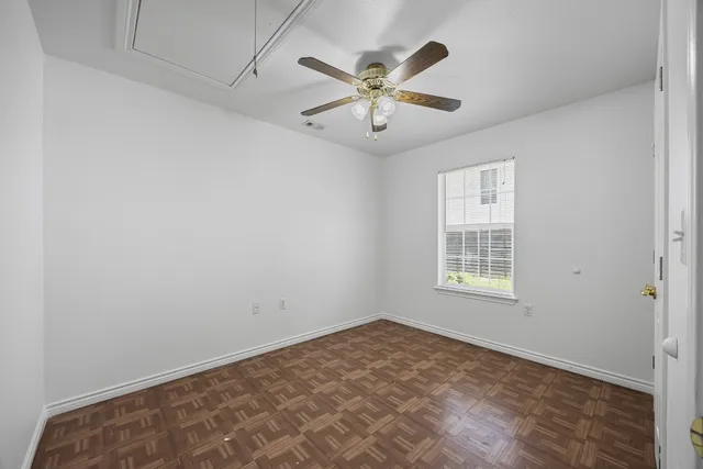 an empty room with windows and fan
