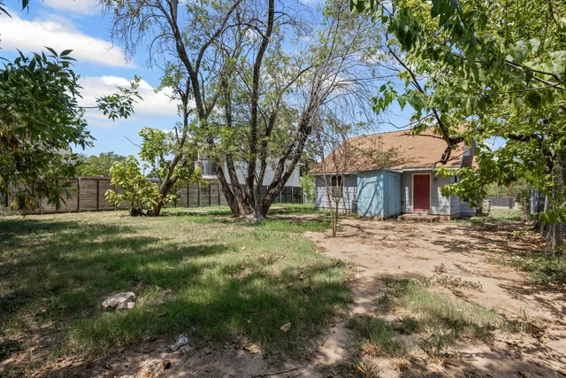a view of a house with a yard and tree s