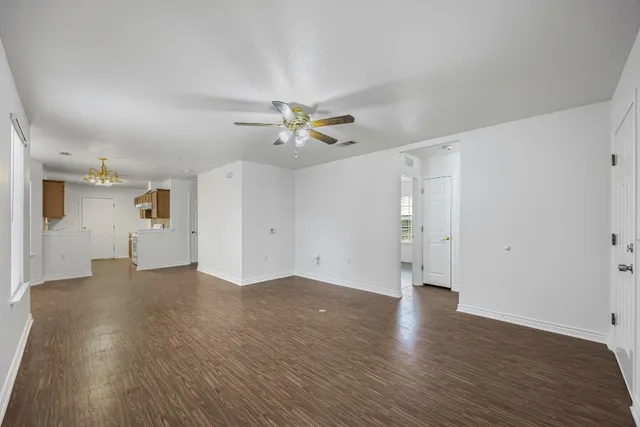 a view of a livingroom with wooden floor and a ceiling fan