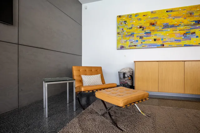 a living room with furniture a flat screen tv and a floor to ceiling window