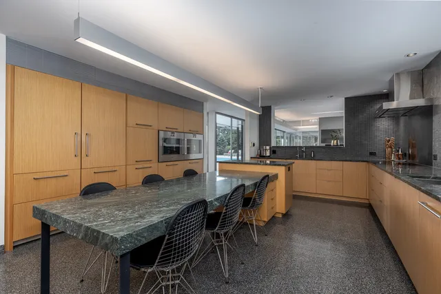 a large white kitchen with stainless steel appliances granite countertop cabinets and a window