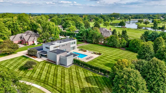 an aerial view of a house with a garden and swimming pool