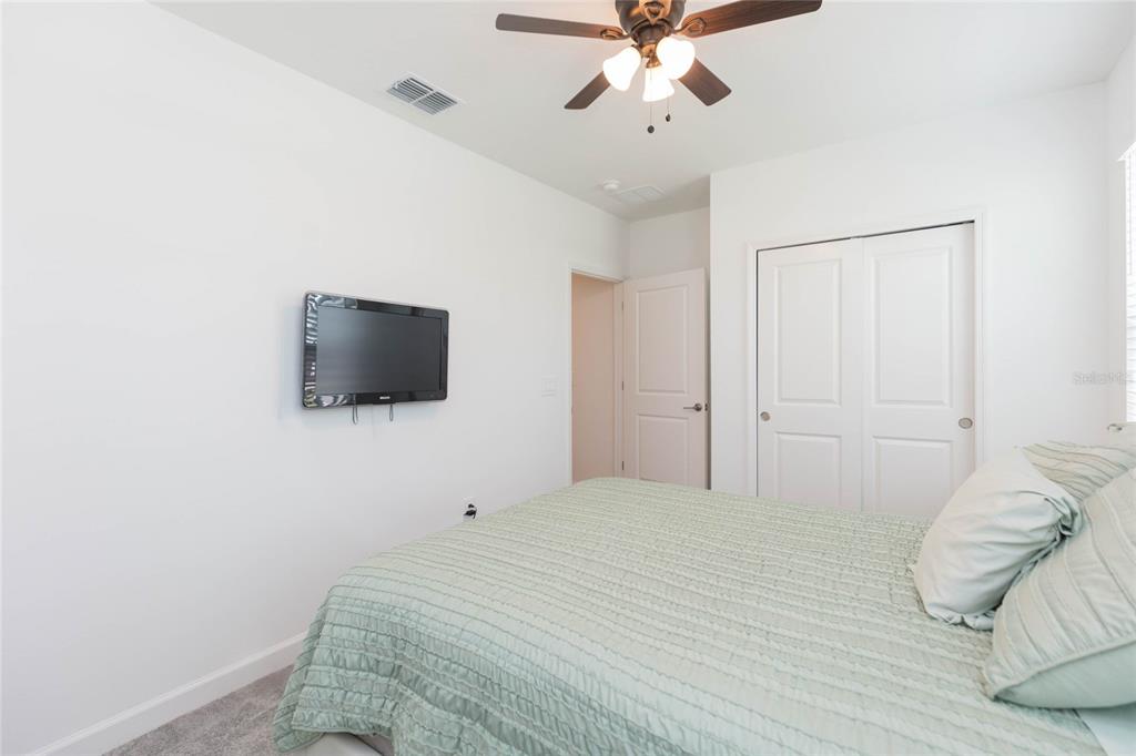 10806 Gable Dig Loop San Antonio, FL 33576 - Photo 34 of 73 a bedroom with a bed and a flat screen tv