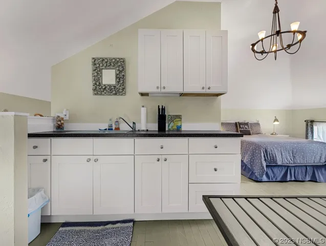 a kitchen with stainless steel appliances white cabinets and wooden floor