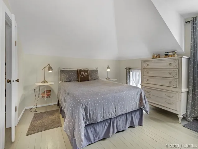 a bedroom with a bed and a dresser next to a window