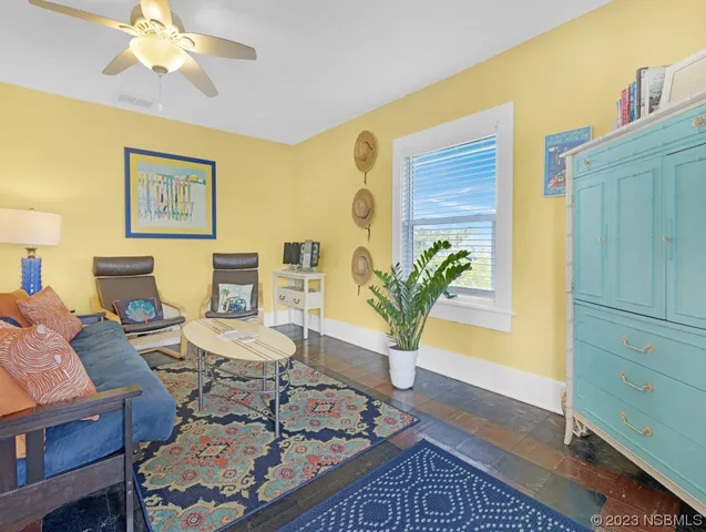 a view of a dining room with furniture a kitchen and wooden floor