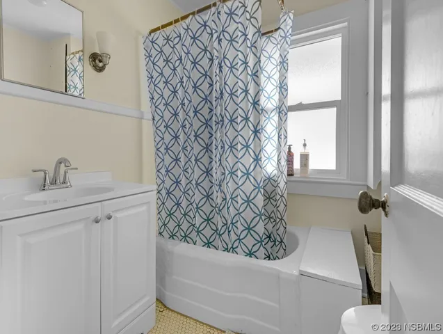 a bedroom with a bed couch and a large window