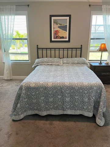 a bedroom with a bed next to a window