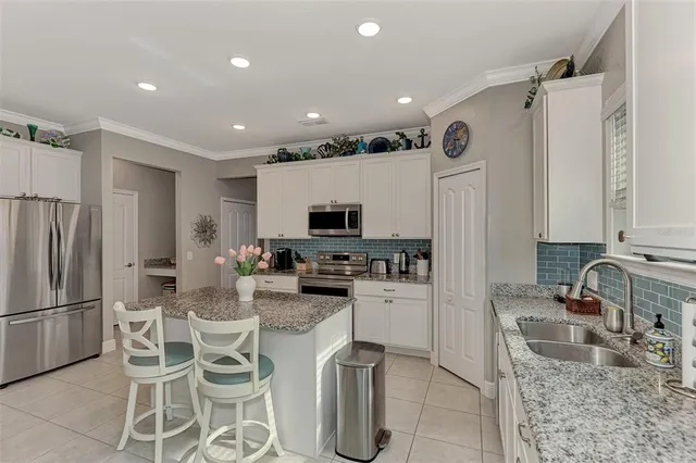 a kitchen with stainless steel appliances granite countertop a sink refrigerator and cabinets