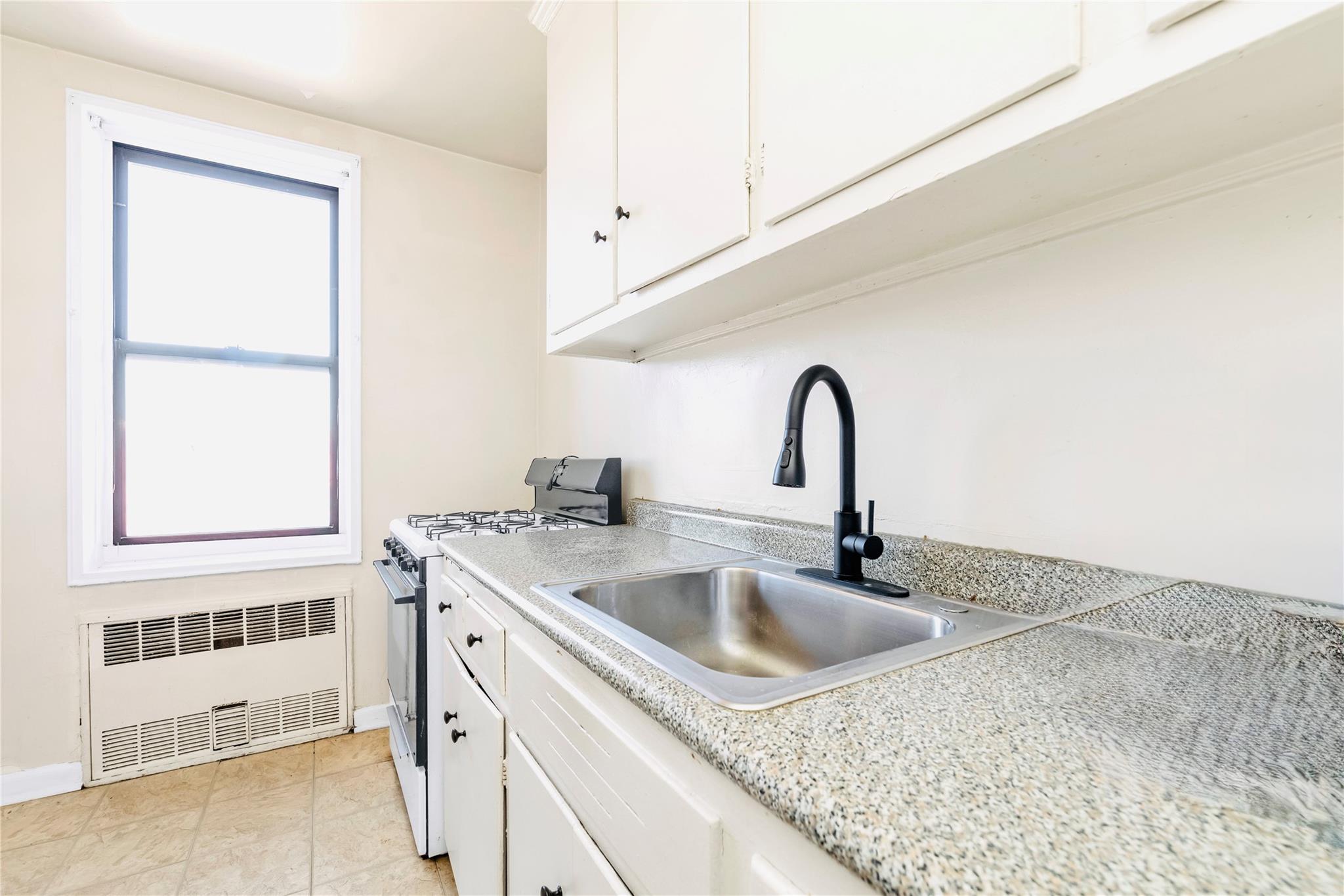 141-05 Pershing Crescent, Unit 511 Queens, NY 11435 - Photo 12 of 14 a close view of a sink a faucet and appliance in the kitchen