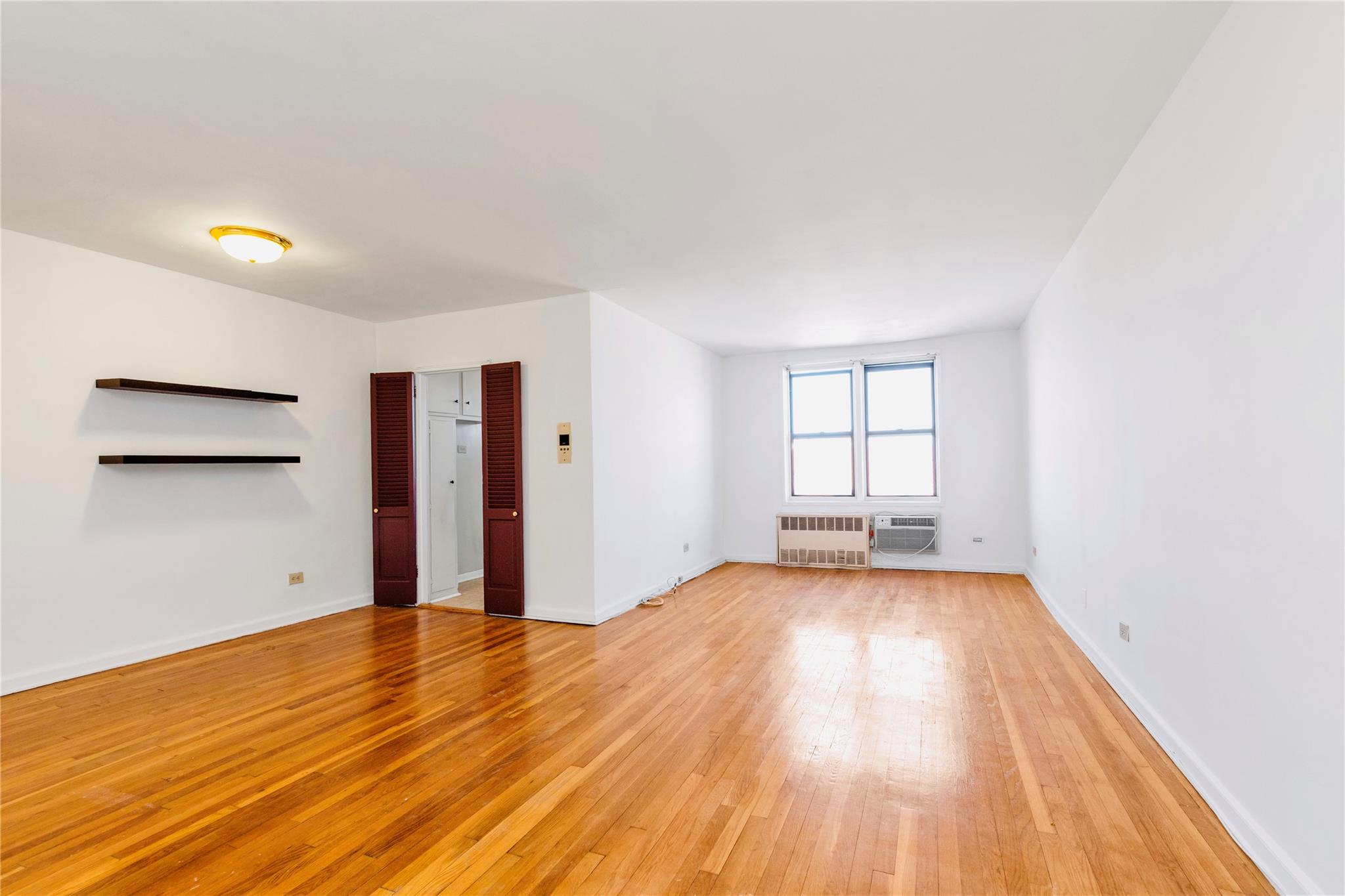 141-05 Pershing Crescent, Unit 511 Queens, NY 11435 - Photo 6 of 14 a view of a room with wooden floor and window