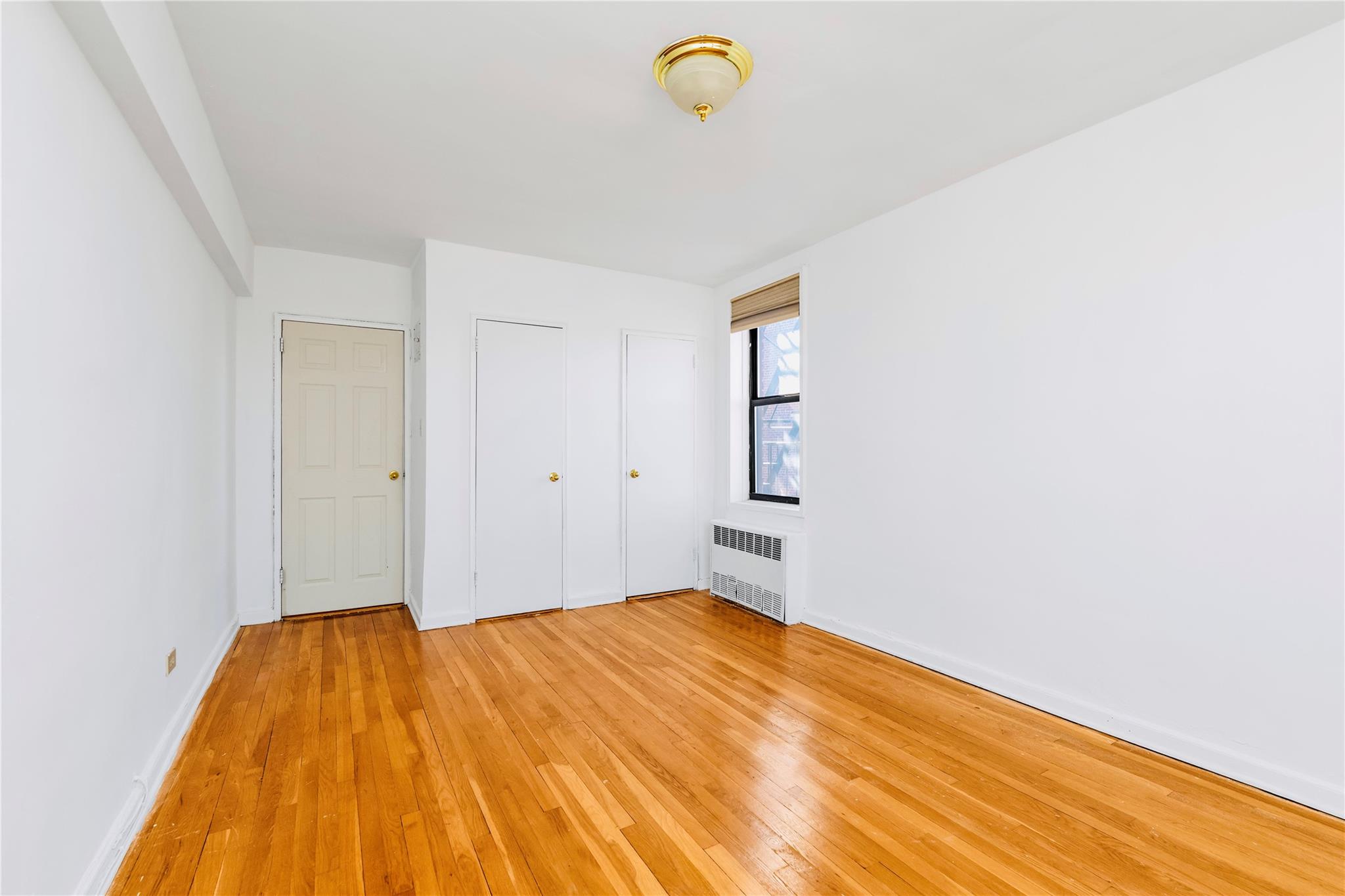 141-05 Pershing Crescent, Unit 511 Queens, NY 11435 - Photo 7 of 14 a bedroom with a bed and a window