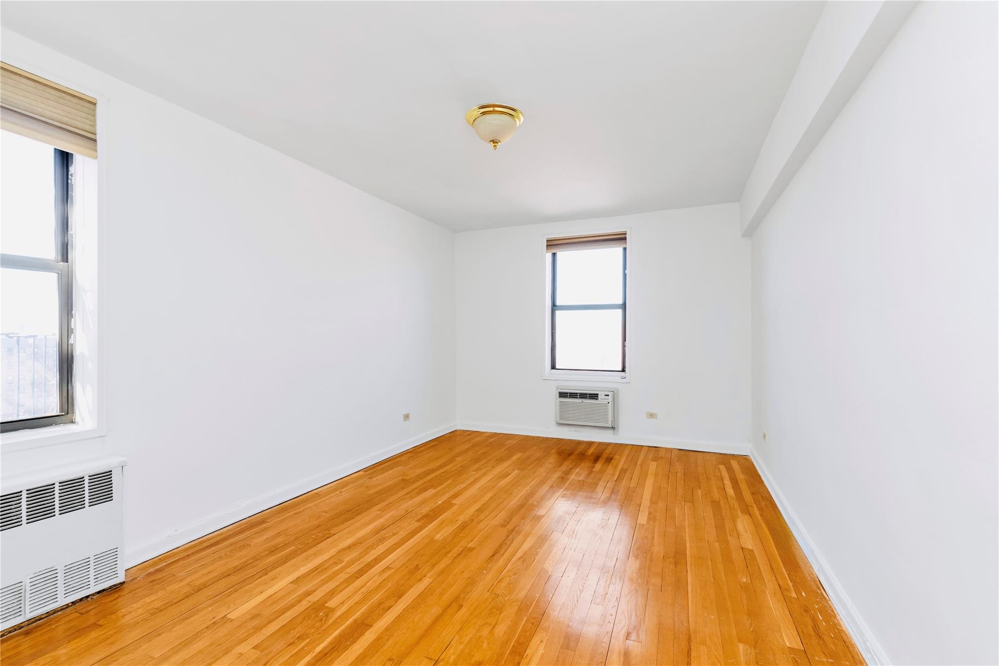 141-05 Pershing Crescent, Unit 511 Queens, NY 11435 - Photo 8 of 14 a view of a big room with wooden floor and windows