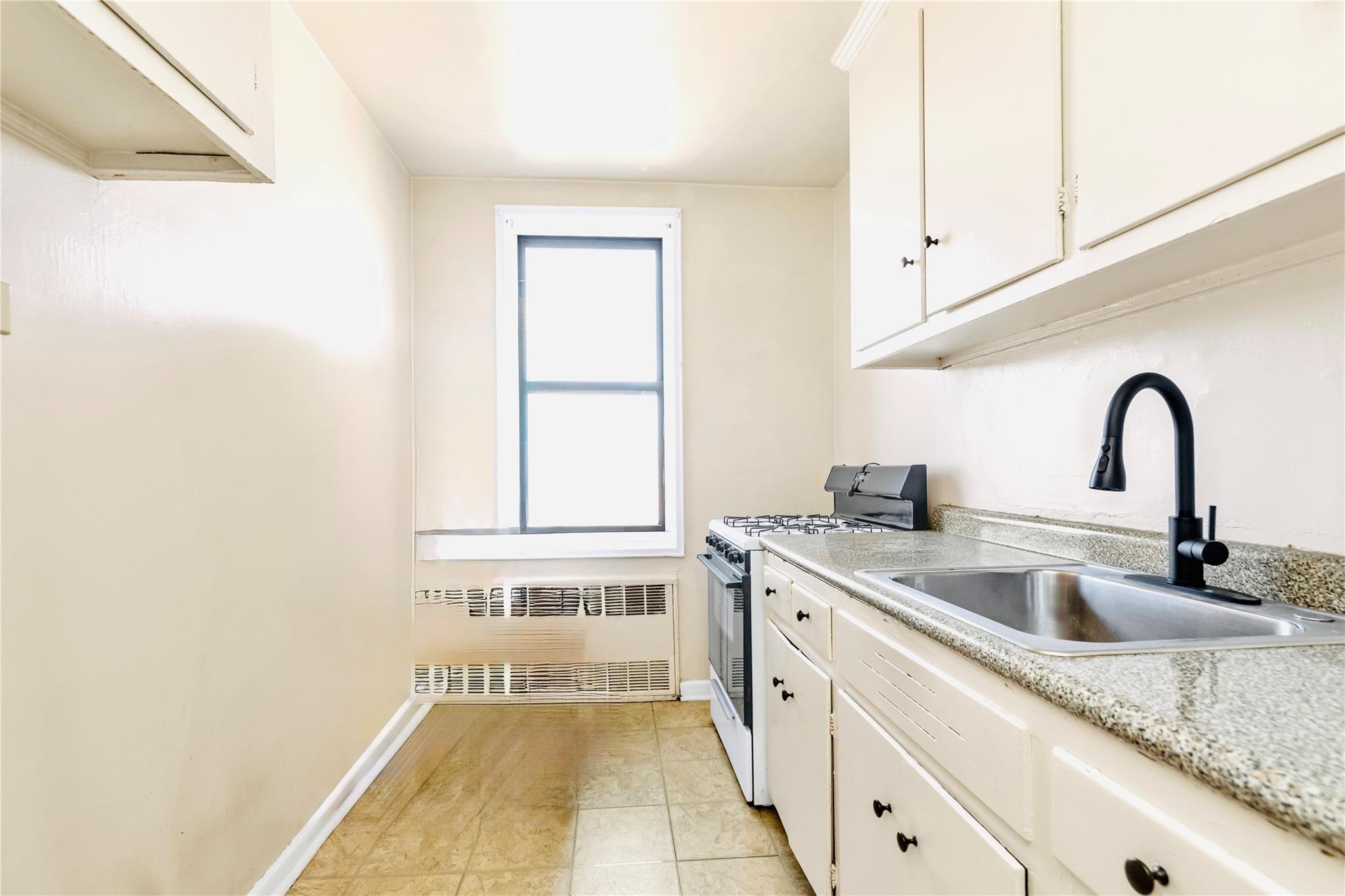141-05 Pershing Crescent, Unit 511 Queens, NY 11435 - Photo 10 of 14 a kitchen with a sink and cabinets