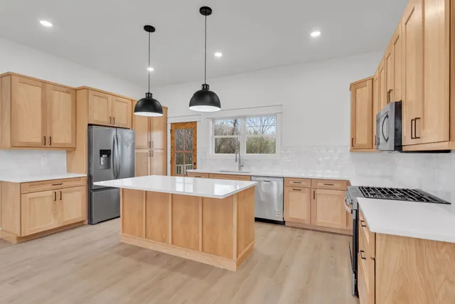 a view of empty room with wooden floor and window