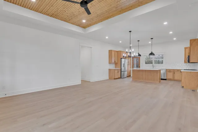 a large kitchen with stainless steel appliances kitchen island granite countertop a stove a sink a refrigerator and a granite counter top