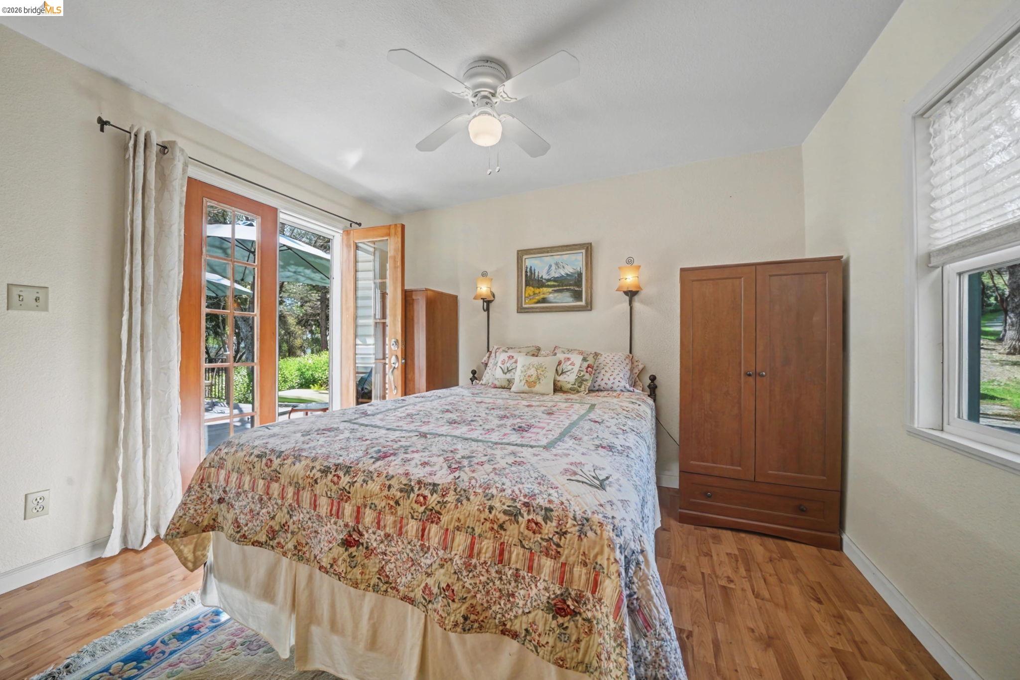 7035 Old Gulch Road San Andreas, CA 95249 - Photo 24 of 45 Bedroom with access to outside, ceiling fan, light wood-type flooring, and multiple windows