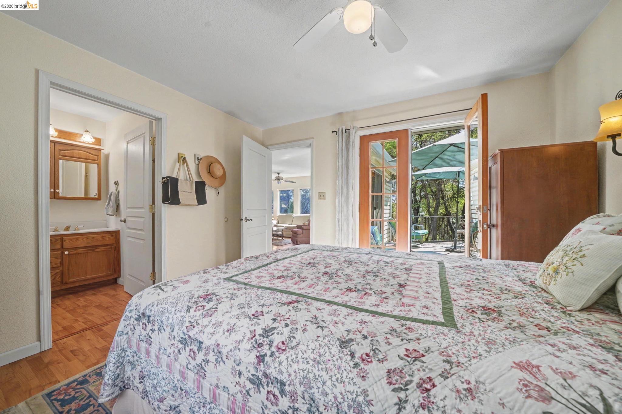 7035 Old Gulch Road San Andreas, CA 95249 - Photo 25 of 45 Bedroom with access to outside, light wood-style floors, a ceiling fan, and ensuite bathroom