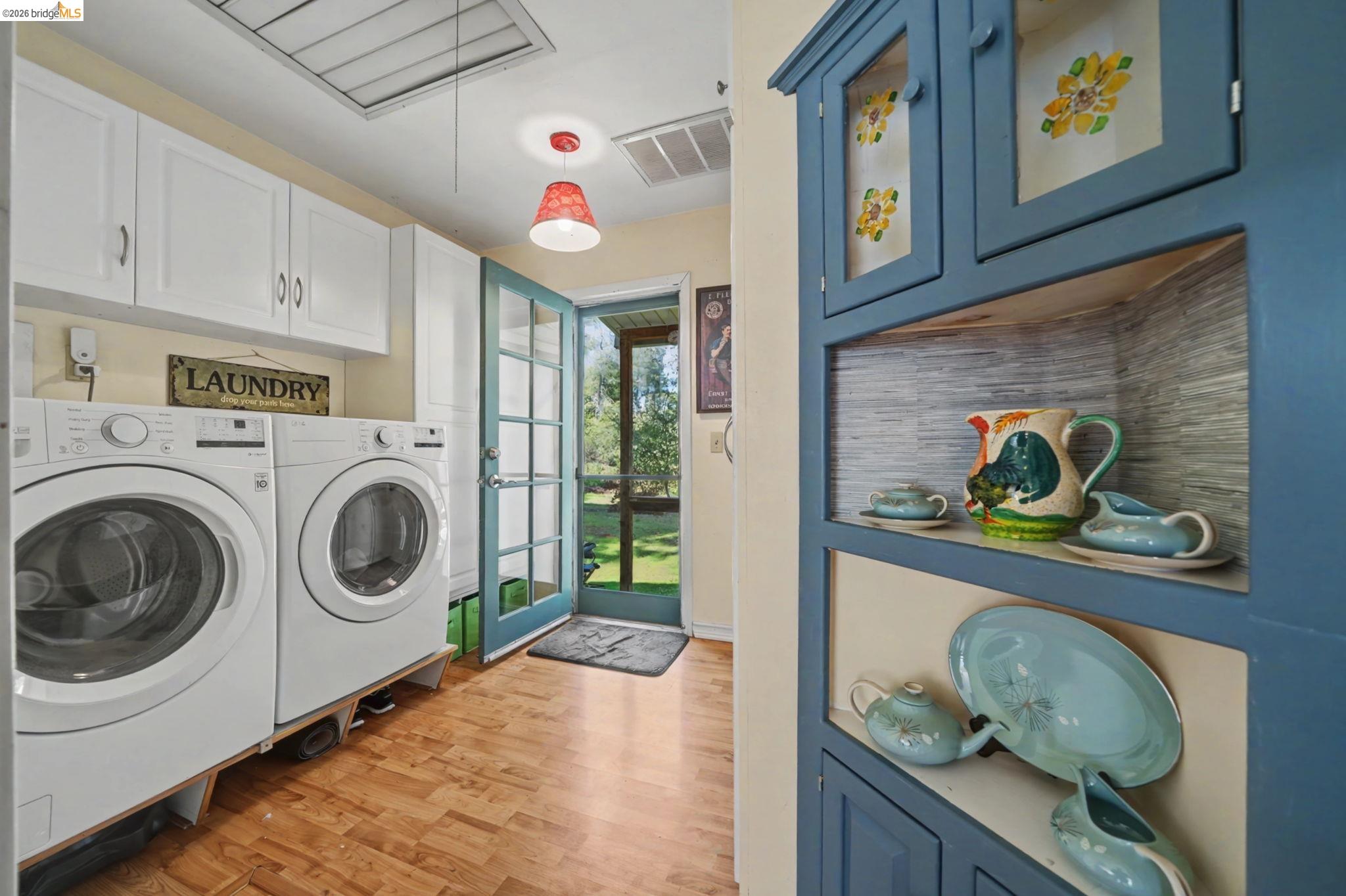 7035 Old Gulch Road San Andreas, CA 95249 - Photo 31 of 45 Laundry area with light wood-style flooring, independent washer and dryer, and cabinet space