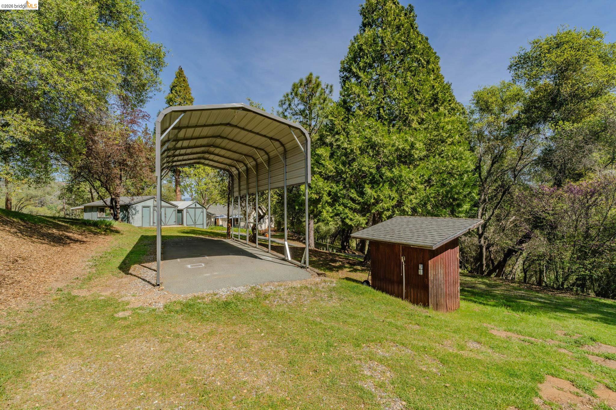 7035 Old Gulch Road San Andreas, CA 95249 - Photo 32 of 45 View of parking with a storage shed, a detached carport, and view of wooded area