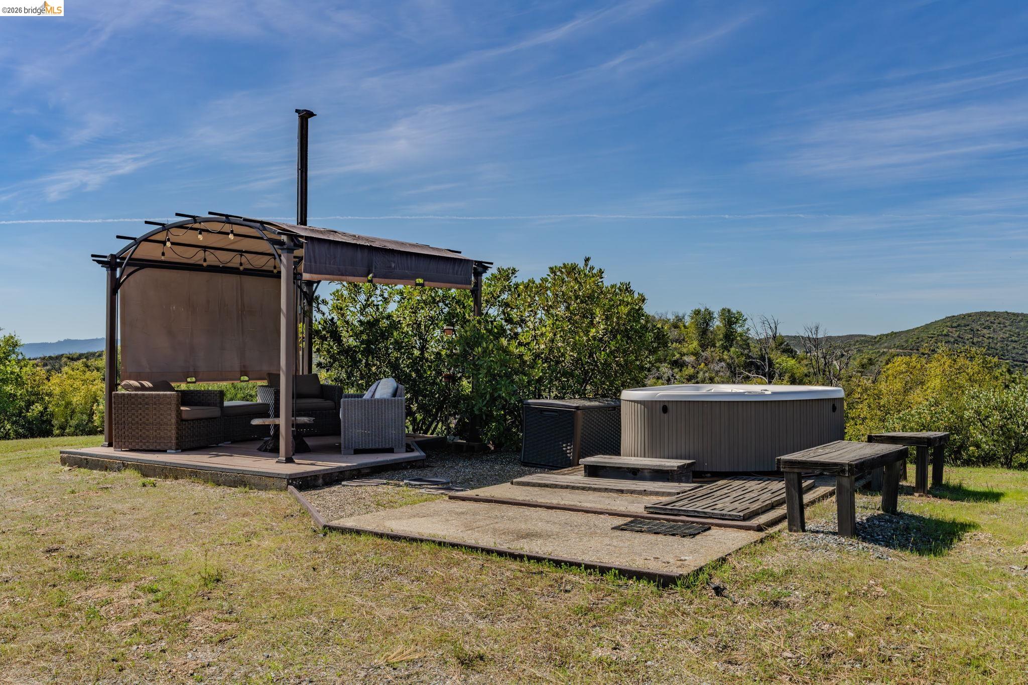 7035 Old Gulch Road San Andreas, CA 95249 - Photo 35 of 45 View of grassy yard with a hot tub, an outdoor living space, a mountain view, and a patio