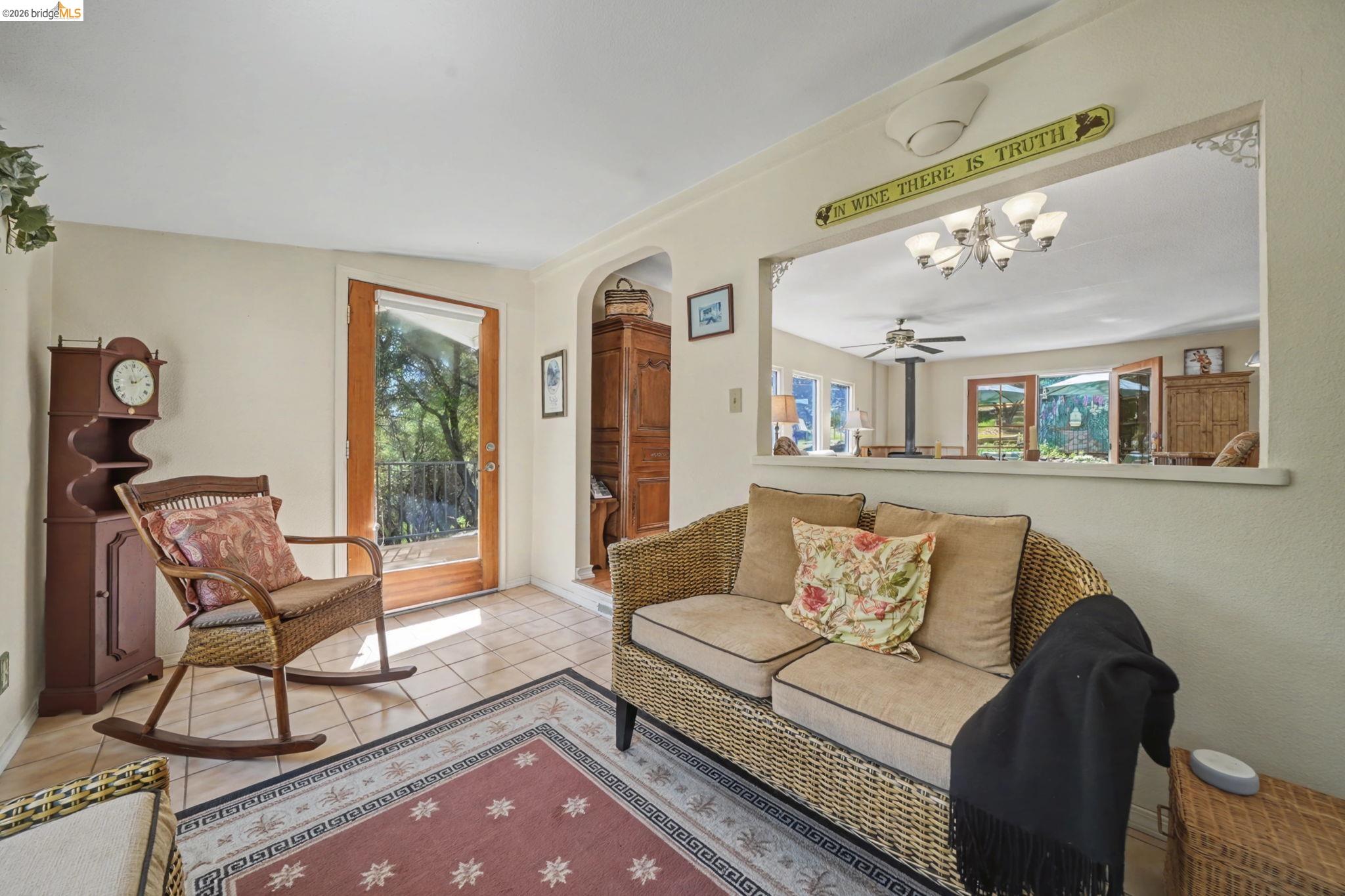 7035 Old Gulch Road San Andreas, CA 95249 - Photo 9 of 45 Living area featuring arched walkways, light tile patterned flooring, a ceiling fan, and hanging lights